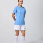 Female model in light blue soccer jersey and white shorts